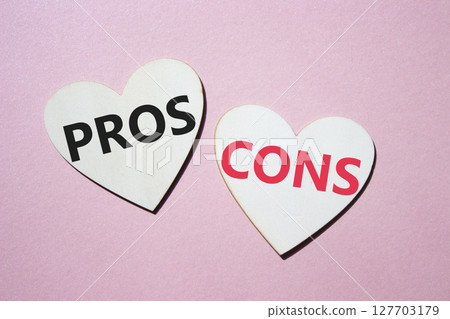 Pros vs Cons symbol. Concept word Pros vs Cons on wooden hearts. Beautiful pink background. Business and Pros vs Cons concept. Copy space 127703179