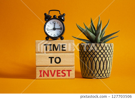 Time to Invest symbol. Concept words Time to Invest on wooden blocks. Beautiful orange background with alarm clock and succulent plant. Business and Time to Invest concept. Copy space Time to Invest symbol. Concept words Time to Invest on wooden blocks. Beautiful orange background with alarm clock and succulent plant. Business and Time to Invest concept. Copy space 127703506
