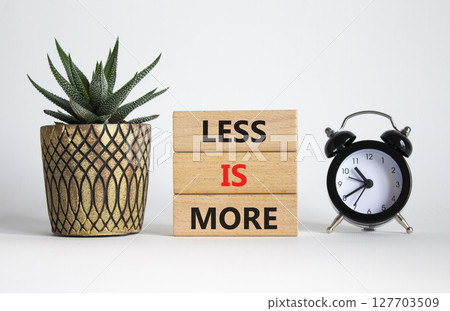 Less is More symbol. Concept words Less is More on wooden blocks. Beautiful white background with succulent plant and alarm clock. Business and Less is More concept. Copy space. 127703509