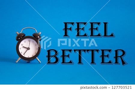 Feel better symbol. Beautiful blue background with alarm clock. Business and Feel better concept. Copy space. Feel better symbol. Beautiful blue background with alarm clock. Business and Feel better concept. Copy space. 127703521