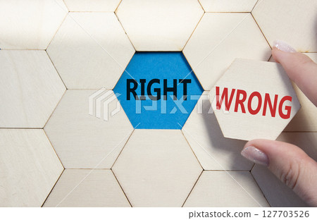 Right or Wrong symbol. Concept word Right or Wrong on wooden comb puzzle. Businessman hand. Beautiful blue background. Business and Right or Wrong concept. Copy space 127703526