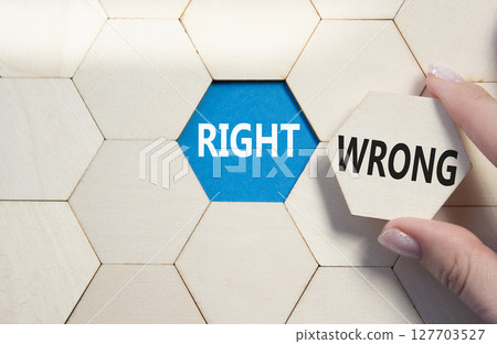 Right or Wrong symbol. Concept word Right or Wrong on wooden comb puzzle. Businessman hand. Beautiful blue background. Business and Right or Wrong concept. Copy space 127703527