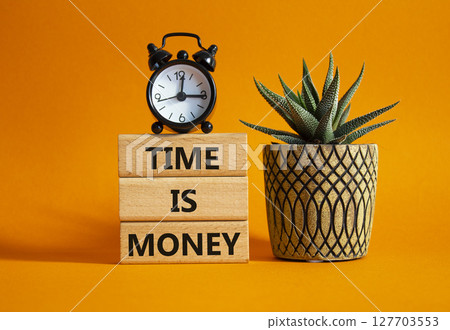 Time is Money symbol. Concept words Time is Money on wooden blocks. Beautiful orange background with alarm clock and succulent plant. Business and Time is Money concept. Copy space 127703553
