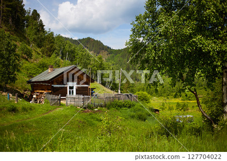 An old country house in the middle of a forest and mountains 127704022