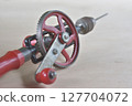 Hand drill placed on a wooden board 127704072