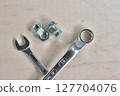 Wrench and screws on a wooden board 127704076