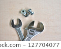 Wrench and screws on a wooden board 127704077