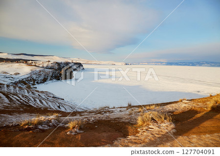 Lake Baikal in winter. View of a frozen lake covered with snow. 127704091