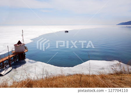 Lake Baikal in spring. A hovercraft transports tourists Lake Baikal in spring. A hovercraft transports tourists 127704110