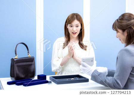 一位女士正在接受買家的包包和貴金屬估價 127704213