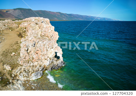 Lake Baikal. Turquoise water color. A rock with a hole in the shape of a heart on Cape Tsagan-Khushun 127704320