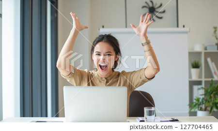 Excited businesswoman celebrating success at office desk with laptop, happy female worker enjoying great achievement, victory or good business news Excited businesswoman celebrating success at office desk with laptop, happy female worker enjoying great achievement, victory or good business news 127704465