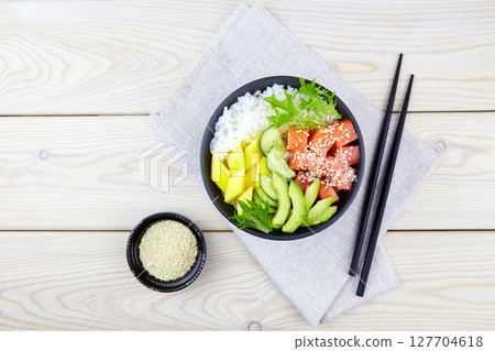 Poke bowl with salmon, rice, avocado, cucumber, mango, herbs. Hawaiian ahi. Poke bowl with salmon, rice, avocado, cucumber, mango, herbs. Hawaiian ahi. 127704618