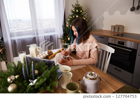 A young girl cooks Christmas gingerbread at home in the kitchen. A young girl cooks Christmas gingerbread at home in the kitchen. 127704753