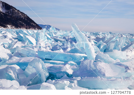 Piles of blue ice fragments covered in snow. Piles of blue ice fragments covered in snow. 127704778