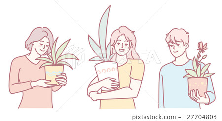 Three individuals are holding various indoor plants that exhibit soft and calming colors 127704803