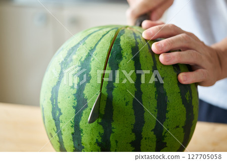 Man splitting a watermelon 127705058