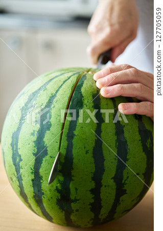 Man splitting a watermelon 127705059