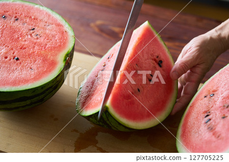man cutting watermelon 127705225