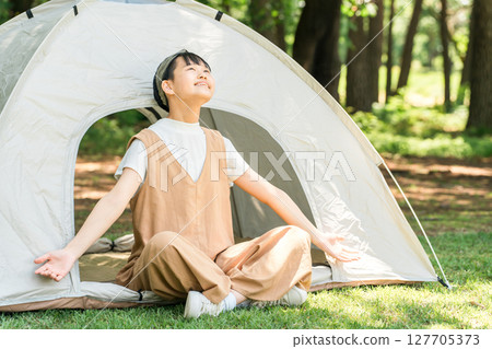 一個女孩在露營地的帳篷外深呼吸,在森林裡放鬆 一個女孩在露營地的帳篷外深呼吸,在森林裡放鬆 127705373