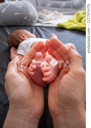 Tender Moment: Adult Hands Holding Newborn Baby Feet 127705479