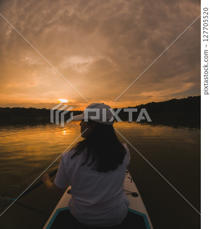 Paddleboarding at Sunset on a Calm Lake 127705520
