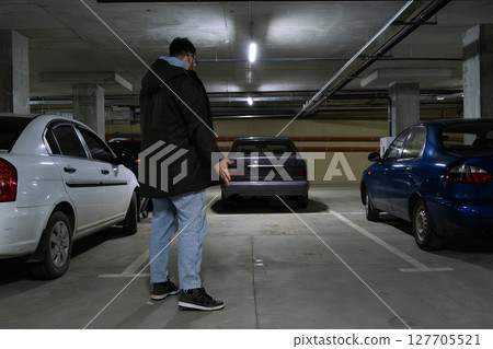 Person in Underground Parking Garage Figure Out of Stolen Car Person in Underground Parking Garage Figure Out of Stolen Car 127705521