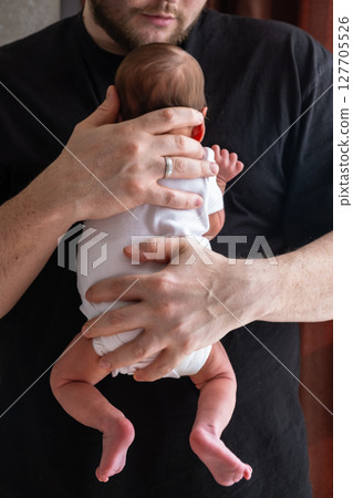 Man Holding Newborn Baby in Tender Moment 127705526