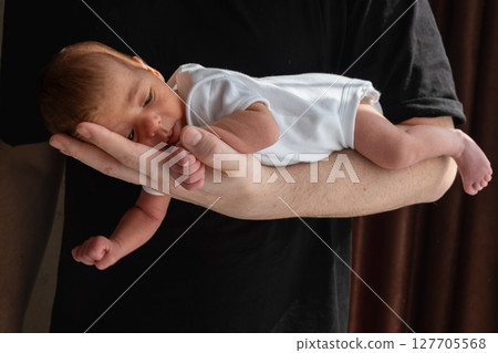 Newborn Baby Cradled in Hand 127705568
