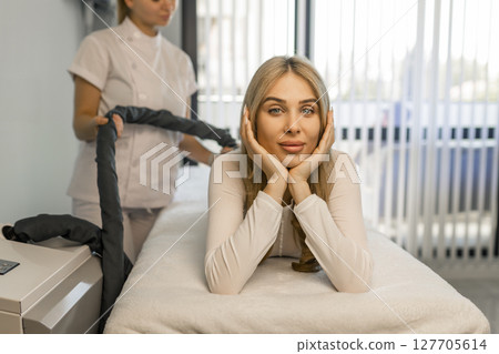 Woman in special white suit getting anti cellulite massage in a spa salon. LPG, and body contouring treatment in clinic.Reset body weight with LPG massage.  127705614