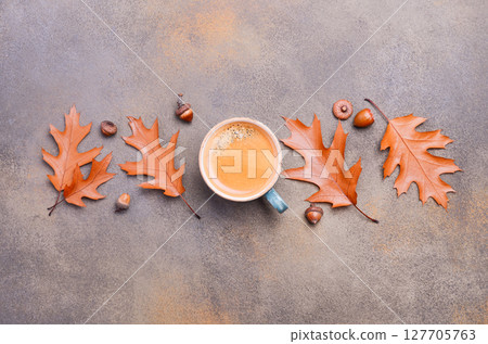 Warm cup of coffee surrounded by autumn leaves and acorns on textured surface, creating a cozy seasonal atmosphere for fall inspiration Warm cup of coffee surrounded by autumn leaves and acorns on textured surface, creating a cozy seasonal atmosphere for fall inspiration 127705763