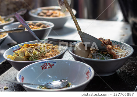 Preparing Bowls of Traditional Indonesian Soto Soup Preparing Bowls of Traditional Indonesian Soto Soup 127705897