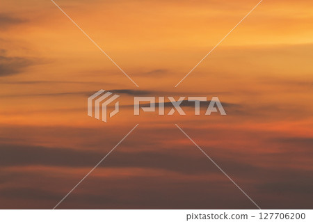 Dramatic orange and yellow sky with dark clouds at sunset 127706200