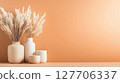 Neutral home decor featuring dried flowers in vases and candles against a soft orange backdrop for a warm ambiance in interior design 127706337
