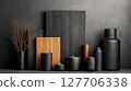 Decorative arrangement of black vases and candles with wooden panels in a minimalist setting 127706338