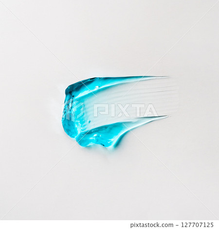 A smear of blue cosmetic hair gel on a white background A smear of blue cosmetic hair gel on a white background 127707125