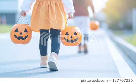 孩子們穿著萬聖節服裝，帶著南瓜籃在附近散步 127707220