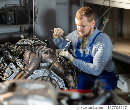 experienced mechanic repairs the engine 127708337
