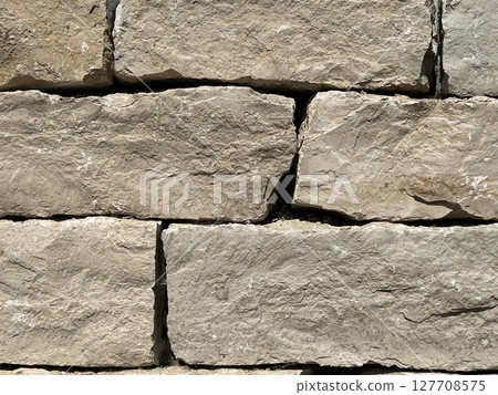 Textured stone background with irregularly shaped gray stones arranged in a pattern. Textured stone background with irregularly shaped gray stones arranged in a pattern. 127708575