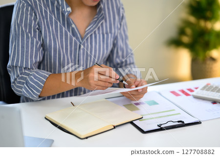 Young entrepreneur checking business data at home workspace Young entrepreneur checking business data at home workspace 127708882