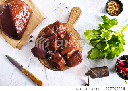 Raw Beef liver meat on wooden board with peppers 127709316