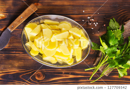 Spiced pieces of raw potato prepared to bake. Spiced pieces of raw potato prepared to bake. 127709342
