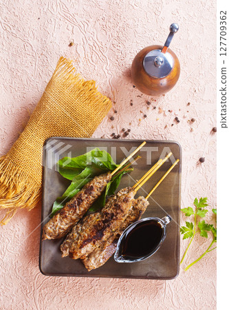 Grilled Lula kebab on skewers with spices in a claim plate on a table 127709362