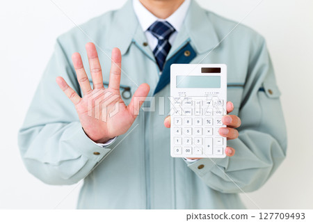 A middle-aged male businessman wearing green work clothes, holding a calculator and pointing five fingers up A middle-aged male businessman wearing green work clothes, holding a calculator and pointing five fingers up 127709493