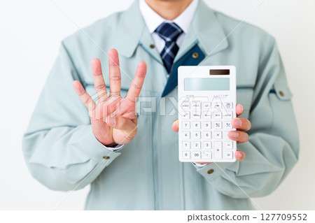 A middle-aged male businessman wearing green work clothes, holding a calculator and pointing four fingers up 127709552