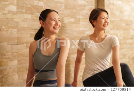 做扭轉瑜珈姿勢的女性 做扭轉瑜珈姿勢的女性 127709814