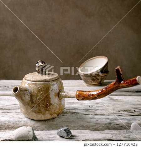 Ceramic teapot with wooden handle 127710422
