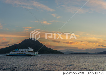日落時分駛離港口的渡輪 127710738