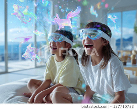Two girls looking at AR glasses in the living room 127710788