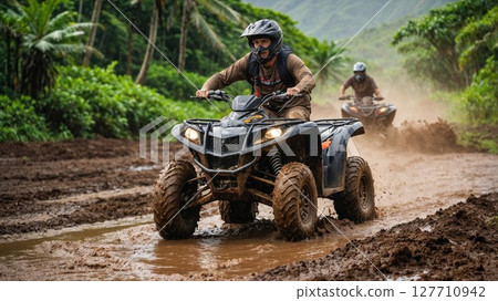Two men are riding allterrain vehicles through a muddy field area Two men are riding allterrain vehicles through a muddy field area 127710942